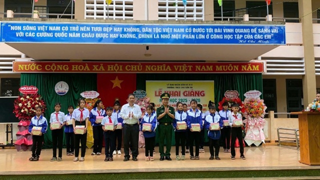 Đại diện xã Ia O và Ban Chỉ huy Bộ đội Biên phòng tỉnh trao quà cho các em học sinh tại lễ khai giảng